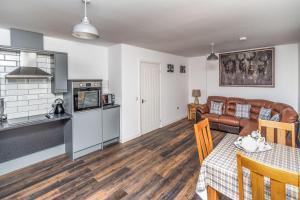 una cucina e un soggiorno con un tavolo e un divano di Sam's Cottage a Keswick Altre 10 foto