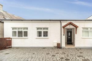 una casa bianca con un vialetto di mattoni di Sam's Cottage a Keswick