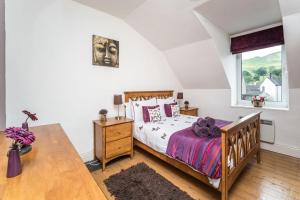 una camera da letto con un letto, una scrivania e una finestra di Stanger Cottage a Keswick