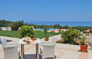 a table and chairs on a patio with a view of a yard at Farm Villas in Mikro Metochi