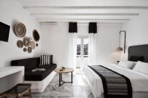 a hotel room with a bed and a couch at Mr & Mrs White Mykonos in Platis Gialos