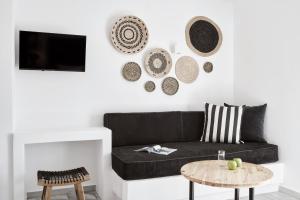 a living room with a black couch and a table at Mr & Mrs White Mykonos in Platis Gialos