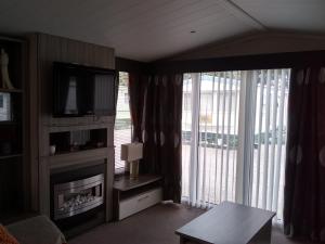 a living room with a fireplace and a television at 57 Tay in Forfar