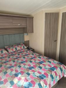 een slaapkamer met een bed met een kleurrijke quilt bij 57 Tay in Forfar