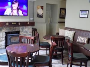 a restaurant with tables and chairs and a fireplace at Flynns of Termonfeckin Boutique Hotel in Termonfeckin