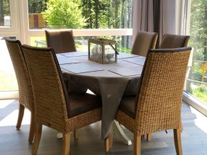 a dining room table with wicker chairs and a table and chairsktop at Ferienchalet-Floesswehrtal in Bad Lauterberg