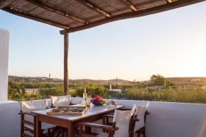 a wooden table and chairs on a patio at Marili Apartments Studios in Parasporos