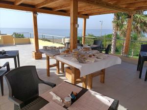a patio with a table and chairs and the ocean at B&B Sale e Sole sul Mare in Avola