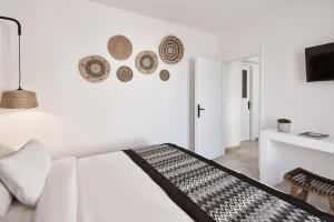 a white bedroom with a bed and a table at Mr & Mrs White Mykonos in Platis Gialos