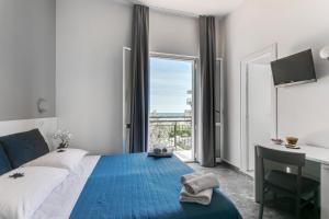 una camera con letto, scrivania e finestra di Hotel Quisisana a Rimini