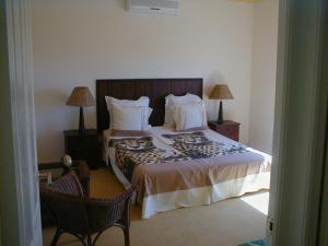 a bedroom with a bed with two chairs and two lamps at Mountain view house 9 Diemersfontein in Wellington