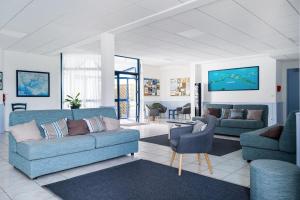 uma sala de estar com dois sofás azuis e uma televisão em Résidence Pierre & Vacances La Voile d'Or em Ile aux Moines