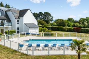 una imagen de una piscina con sillas y una casa en Résidence Pierre & Vacances La Voile d'Or, en Ile-aux-Moines