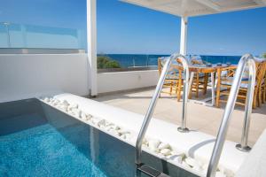 a balcony with a plunge pool and a table and chairs at Aegean Melody Suites in Vlychada