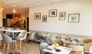 a restaurant with tables and chairs in a room at Residhome Toulouse Occitania in Toulouse