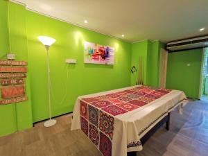 a green room with a table and a lamp at AV HomeStay - Kuching MJC in Kuching
