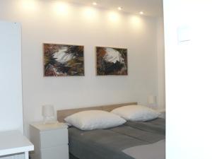 a bedroom with three paintings on the wall at CENTRUM in Włocławek
