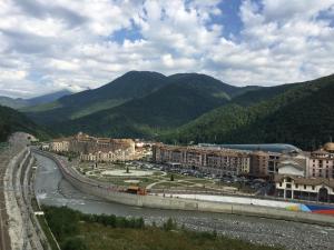 a city with a river and mountains in the background at Gorky Gorod Collection in Estosadok