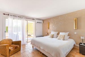 a bedroom with a large white bed and a chair at La Petite Aiguebonne in Allex +168 photos