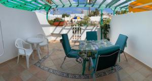 a patio with a glass table and chairs on a balcony at Felicidad in Playa del Ingles