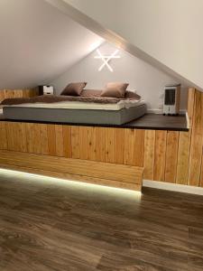 sypialnia z łóżkiem na drewnianej platformie w obiekcie Black Horse Apartament’s w mieście Chojnice