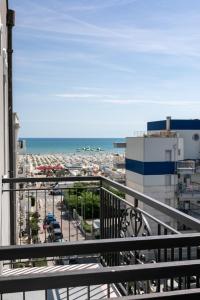 a balcony with a view of a city and the ocean at Hotel Quisisana in Rimini
