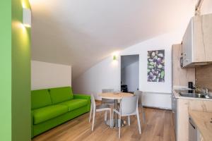 un soggiorno con divano verde e tavolo di Giorgi Design Homes I by Wonderful Italy a Bologna