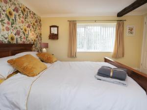 a bed with two pillows and a bag on it at 3 Springfort Cottages in Penrith