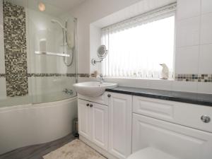 a bathroom with a sink and a tub and a toilet at 3 Springfort Cottages in Penrith +28 photos