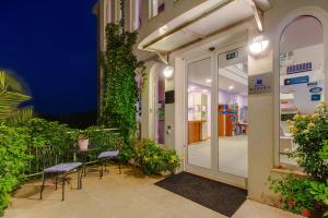 un patio con mesa y sillas fuera de un edificio en Hotel Manora en Nerezine