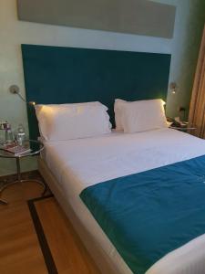 a bedroom with a large bed with a green headboard at One Private Studio full view in Hersonissos