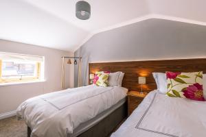 a bedroom with two beds and a window at Brecks Farm - The Mill in York