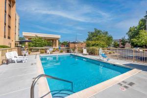 a swimming pool with chairs and a fence at Comfort Inn Elizabeth City near University in Elizabeth City