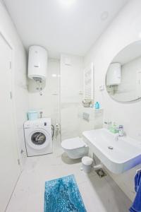 ein weißes Badezimmer mit einem Waschbecken und einer Waschmaschine in der Unterkunft Apertment Mountain view in city center in Bar