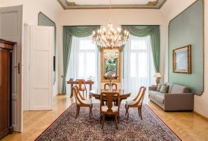 Palais-Hotel Erzherzog Johann في غراتس: غرفة معيشة مع طاولة وكراسي وأريكة