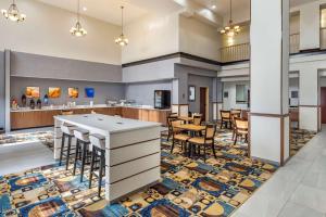 a lobby with a bar and tables and chairs at Comfort Suites in Clovis