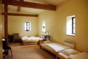 a room with three beds and two windows at PENZION PIVOVAR - Jedinečné ubytování v areálu bývalého pivovaru in Rudník