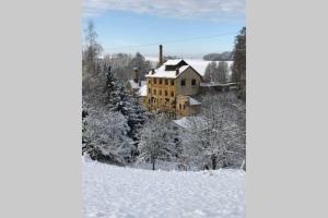 a house in the snow with snow covered trees at PENZION PIVOVAR - Jedinečné ubytování v areálu bývalého pivovaru in Rudník