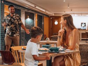 a woman and a boy sitting at a table in a restaurant at ibis Styles Golden Sands Roomer Hotel in Golden Sands