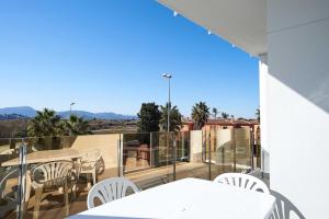 a white table and chairs on a balcony with a view at Green 12, 1 dormitorio, Oliva Nova, by Bookindenia in Oliva