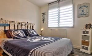 a bedroom with a large bed with a hockey bedspread at Cap Coz Cottage 4* a 500 m de la plage de sable fin in Fouesnant