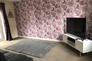 una sala de estar con un mural de rosas en la pared en Dudley House **Staycation & Contractors** Sleeps 7, en Tipton