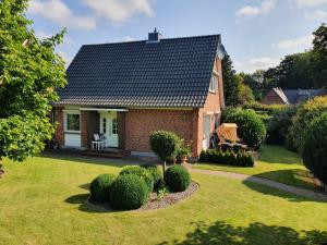 a small brick house with a black roof at Ferienhaus - Dorfperle Borstel in Borstel