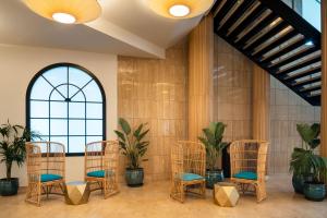 a group of chairs in a room with plants at Arrecife Gran Hotel & Spa in Arrecife