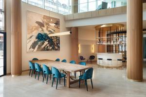 a conference room with a wooden table and blue chairs at Arrecife Gran Hotel & Spa in Arrecife