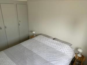 een slaapkamer met een bed met een witte sprei bij Chalet S1 in Workum bij strand en IJsselmeer in Workum