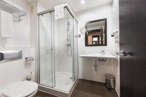 a bathroom with a shower and a toilet and a sink at Hotel CH Bucharest in Bucharest +54 photos