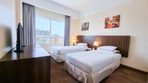 Säng eller sängar i ett rum på Ramada by Wyndham Beach Hotel Ajman