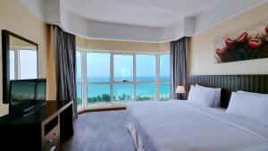 A bed or beds in a room at Ramada by Wyndham Beach Hotel Ajman