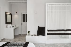 a white room with a bed and a mirror at Mr & Mrs White Mykonos in Platis Gialos